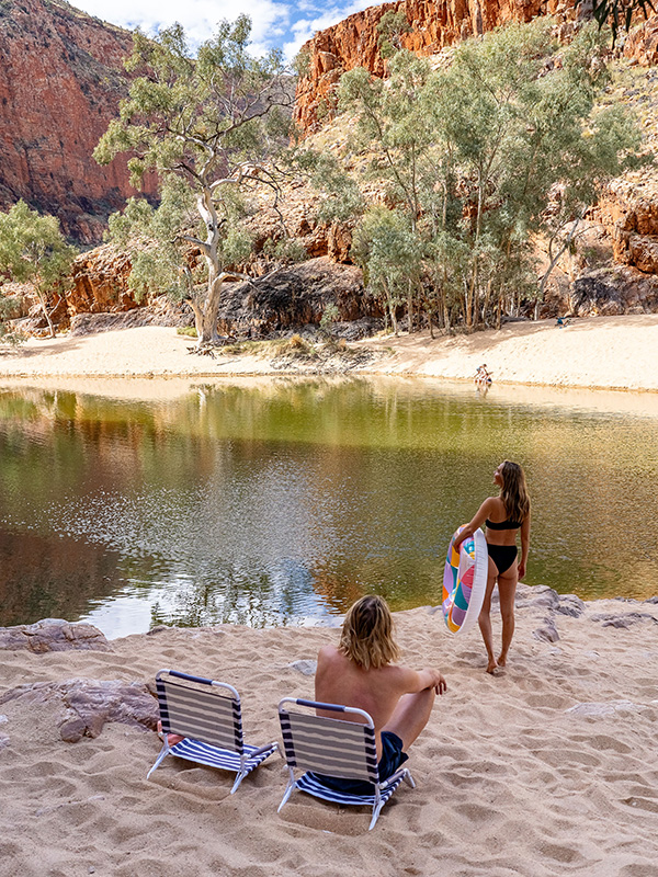 Soaking in the serenity of Ormiston Gorge, these two travellers enjoy one of the most scenic things to do in the Northern Territory.